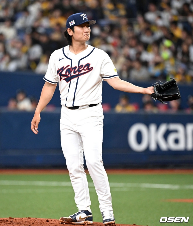 2日，在日本大阪京瓷巨蛋体育场举行的阪神虎队热身赛上，韩国棒球代表队首发投手郭彬投完球后正在接球。