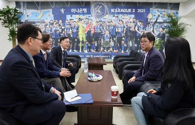 图为崔辉映（右）部长正与职业足球相关人士交换意见。 =文体部。