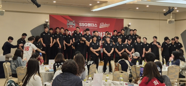 ファンツアーの夕食会で記念撮影のために選手団が舞台の前に出て席を取っている。 /写真=SSGランダース提供