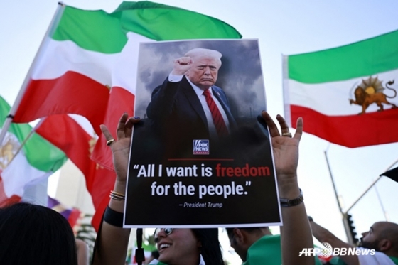 2月28日、米国カリフォルニア州ロサンゼルスでイラン人コミュニティ構成員と支持者がドナルド·トランプ米国大統領の写真を持って祝賀行事をしている。 /AFPBBNews=ニュース1