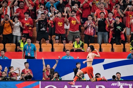 Wang Yu-dong (bên dưới) đang ăn mừng cởi áo bằng cách ghi bàn thắng quyết định bằng cú đá phạt vào phút bù giờ của trận đấu với Bahrain trong trận chung kết vòng loại World Cup Bắc Trung Mỹ 2026 được tổ chức tại sân vận động bóng đá Longxing ở Trùng Khánh, Trung Quốc. /AFPBBNews = Tin tức 1
