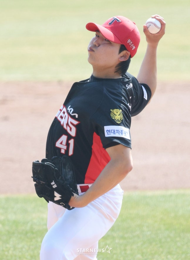 22日，2026新韩SOL Bank KBO联赛表演赛斗山熊队对KIA老虎队的比赛在首尔蚕室棒球场举行。  图为，KIA队的首发投手黄东河正在奋力拼搏。