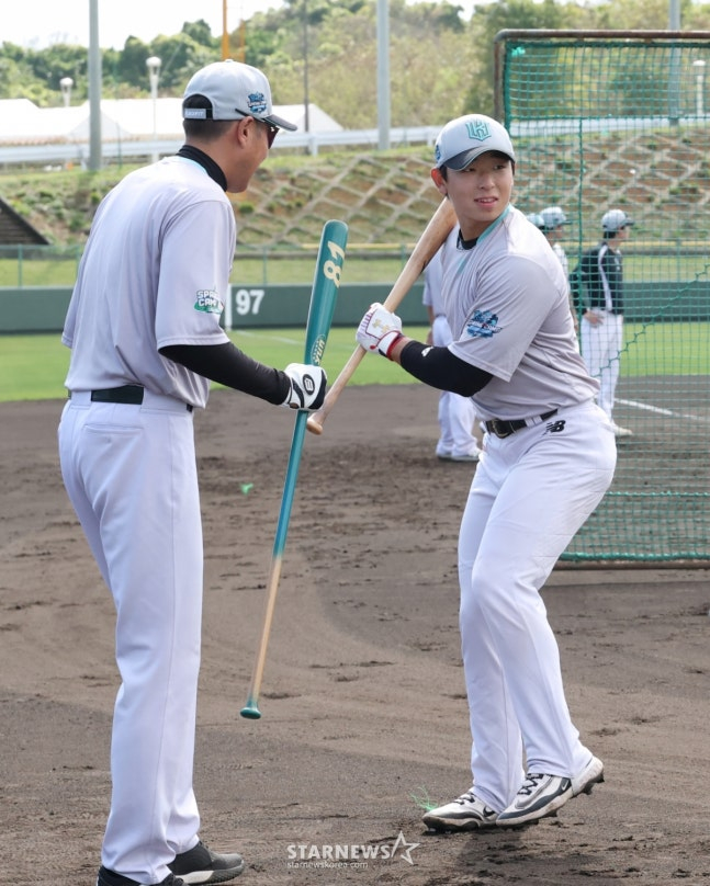 Lee Kang-min (right) is coached by hitting coach Yoo Han-joon at the Okinawa spring camp in Japan last month. /Photo = Senior Reporter Kim Jin-kyung