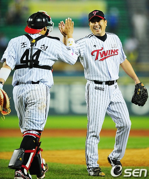 Окамото (справа) делает высокие пять с Чо Ин Сеном, который в то время был основным ловителем.