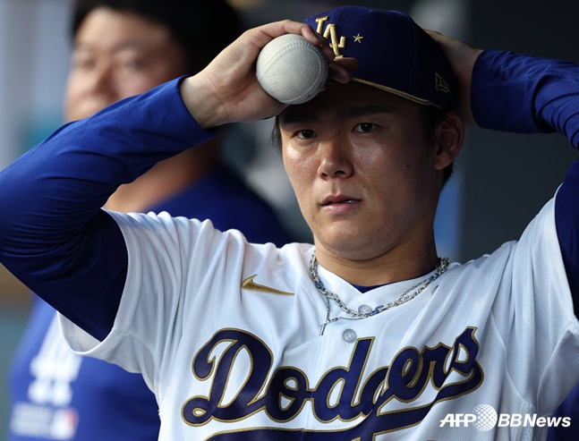 Los Angeles Dodgers pitcher Yoshinobu Yamamoto is watching the players in the dugout during the offense after starting the opening game of the Arizona Diamondbacks and 2026 Major League Baseball (MLB) home on the 27th. /AFPBBNews=News1