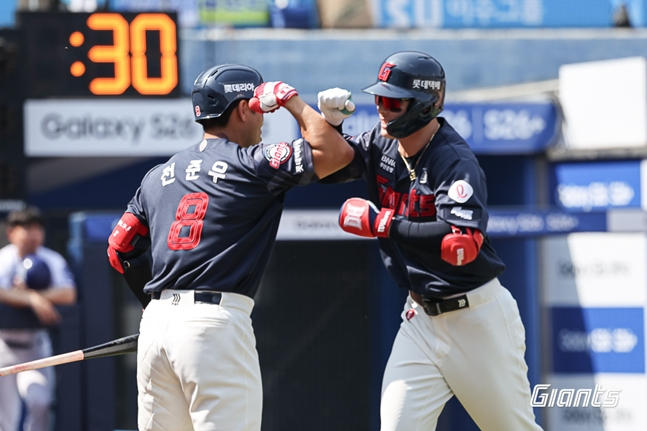 图为，尹东熙（右）在第1局率先打出2分本垒打。 =照片:乐天巨人队。