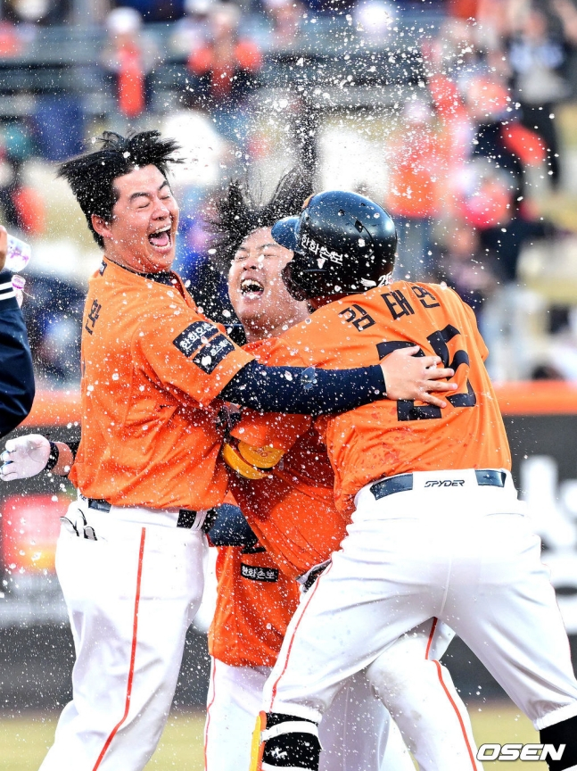 Hanwha Eagles Kang Baek-ho (center) rejoices with Noh Si-hwan (left) and Kim Tae-yeon after hitting a walk-off hit in the bottom of the 11th inning of overtime in the opening game of the 2026 Shinhan SOL KBO League against the Kiwoom Heroes at Hanwha Life Ball Park in Daejeon on the 28th.