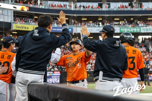 Moon Hyun-bin (giữa) đang nhận được sự hoan nghênh của ban huấn luyện trong trận dugout sau khi ghi bàn. /Ảnh = Hanwha Eaglex cung cấp