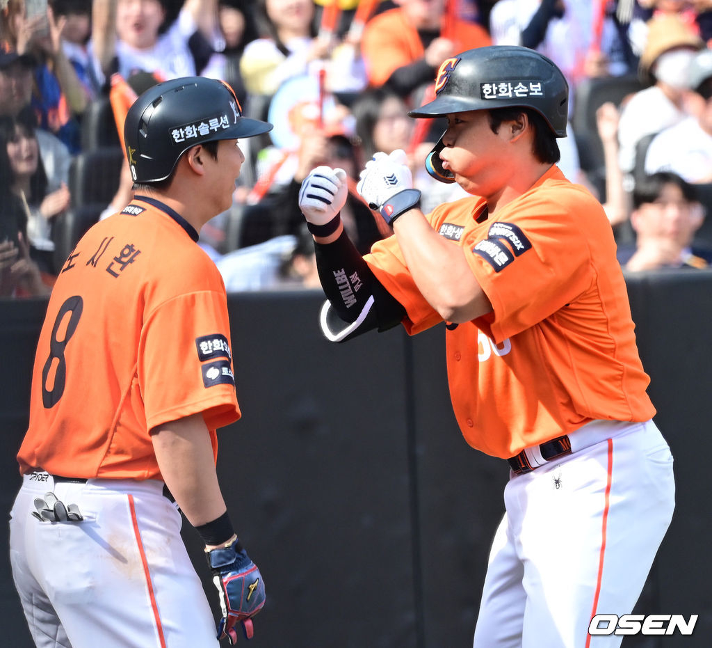 图为，姜白虎（右）击出本垒打，踏上本垒后正与卢时焕一起庆祝。