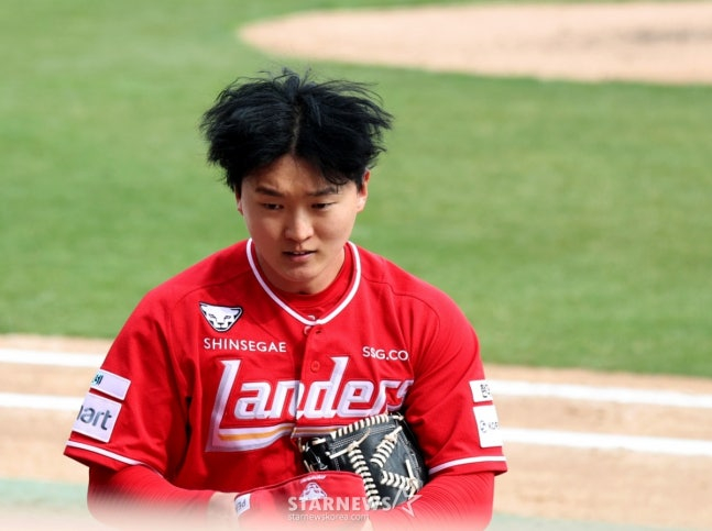 Стартовый питчер «Рандерс» Ким Гон У проходит проверку иностранных тел от судьи Ли Ён Чжэ, когда он уходит из обороны в начале четвертого иннинга 2026 профессионального бейсбола SSG Landers и KIA Tigers на стадионе «Рандерсфилд» в Инчхоне 29-го числа.