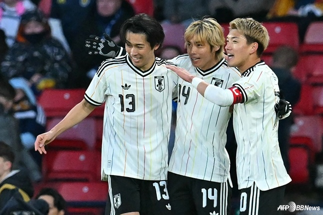 29 числа (по корейскому времени) Джунья Ито (в центре) празднует гол в матче против Шотландии в марте на стадионе Хэмпден Парк в Глазго, Шотландия. /AFPBBNews =Новости 1