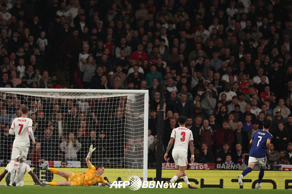 1日，在英国温布利体育场举行的与英格兰队的热身赛上，日本国家足球队水户馨（右）正在率先攻入一球。 =法新社BBNews=新闻1。