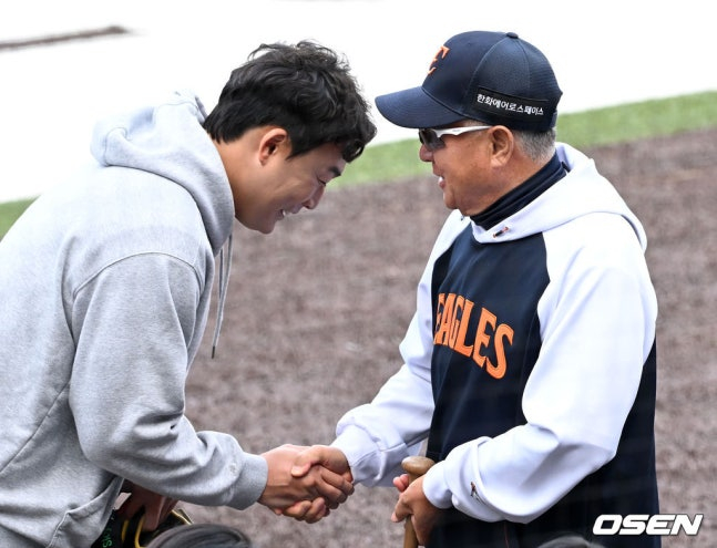 Han Seung-hyuk (left) and Hanwha manager Kim Kyung-moon greet each other ahead of the match on March 31.