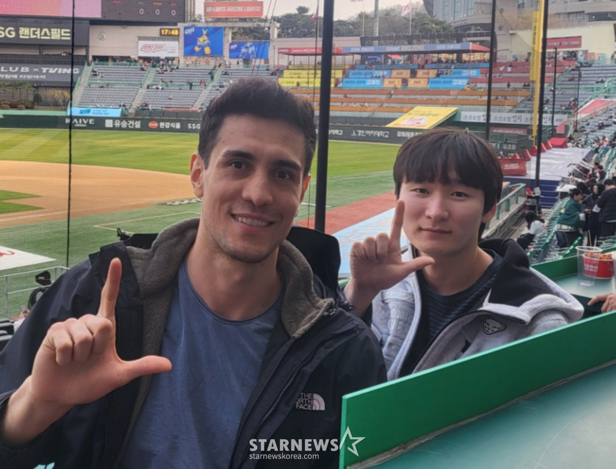 Thẻ Araujo (trái) của chúng tôi đang vẽ chữ 'L' với ý nghĩa cổ vũ chiến thắng của SSG cùng với thông dịch viên người hâm mộ SSG lâu năm. /Ảnh = Phóng viên Ahn Ho-geun