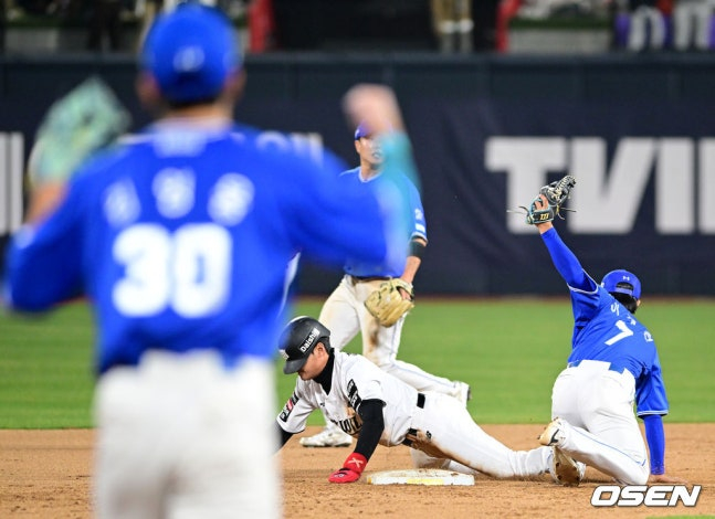 Jang Jin Hyuk (Đồng phục trắng trung tâm) của KT cố gắng đánh cắp căn cứ thứ hai vào cuối hiệp 9 của Suwon Samsung. Kang Min Ho đã bị bắn ra ngoài. 