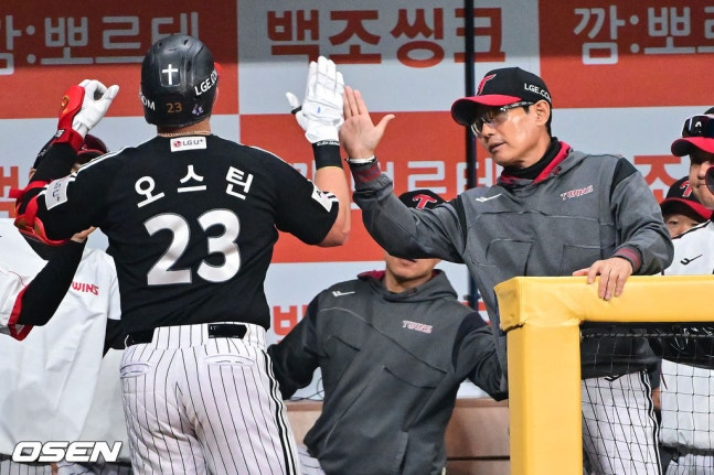 图为，第5局奥斯汀（左）击出1分本垒打后，正与廉景烨教练（右）击掌庆祝。