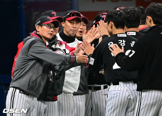 比赛结束后，LG队主教练廉景烨（左）正在与禹康勋击掌庆祝。 