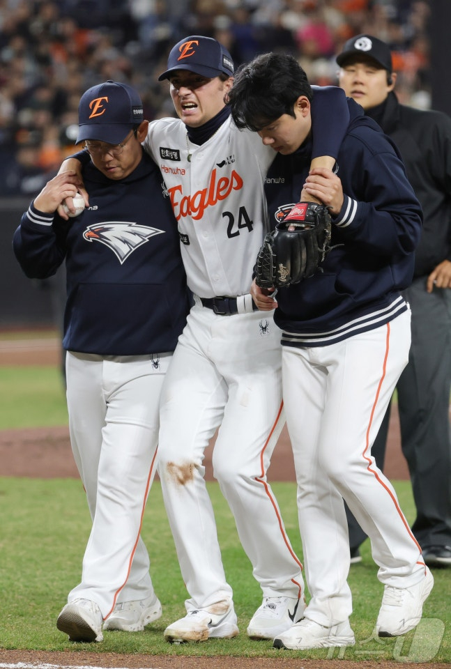 Hanwha White (center) was injured during the KT match on the 31st of last month and is heading to the dugout after being helped by staff. /Photo = News 1