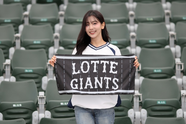 ロッテ·ジャイアンツのモク·ナギョンチアリーダーチーム長がポリテルの応援タオルを持っている。 /写真=ロッテジャイアンツ提供 