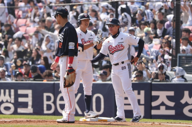 チョン·スビン（中央）が安打を放ち、イム·ジェヒョンコーチ（右）の督励を受けている。 /写真=斗山ベアーズ提供