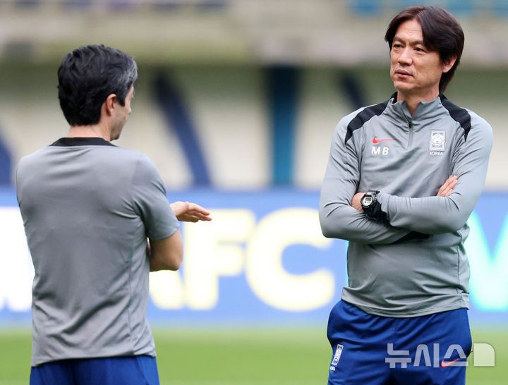 图为正在交谈的朱昂·阿罗索（左）教练和洪明甫教练。 =照片=newsis。