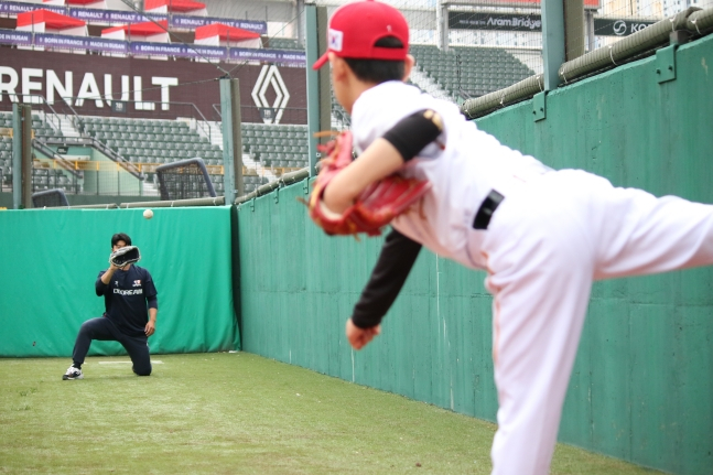 ロッテ選手たちが幼少年選手のボールを受け入れながらフィードバックをしている。 /写真=韓国プロ野球選手協会提供