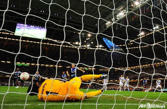 Чон Сон Рён (ниже) блокирует пенальти Аарона Рэмси во время матча против сборной Англии в четвертьфинале Олимпийских игр 2012 года в Лондоне. /AFPBBNews =Новости 1