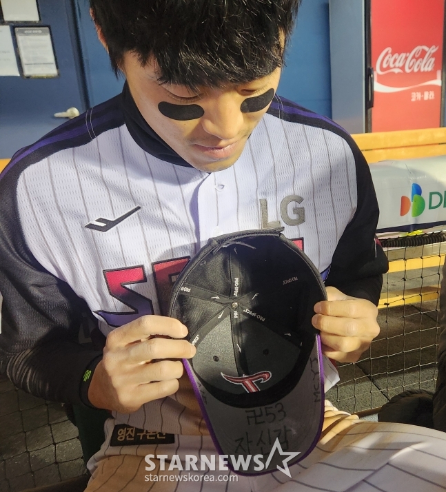 Чон Сон Хо показывает буквы, вырезанные на его шляпе. /Фото = Репортер Ан Хо Гын