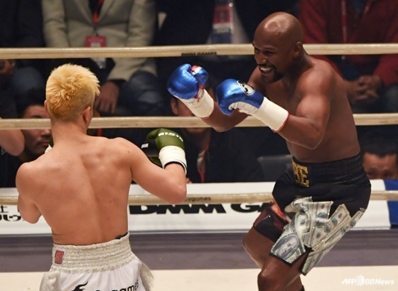 Флойд Мейвезер, широко улыбающийся во время матча с Наска и Теншином (слева). /AFPBBNews =Новости 1