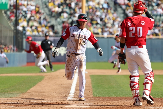 图为吴志焕（中）趁对手的失误攻入本垒。 =照片=LG twins提供。