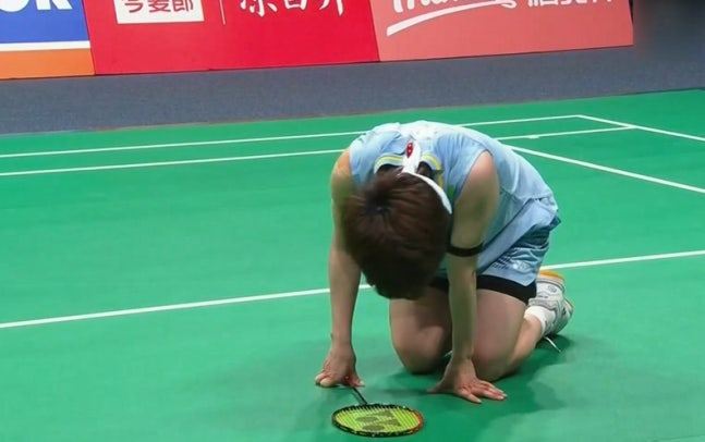 China's Wang Zhiyi, who had a fierce rally with An Se-young in the women's singles final at the 2026 Asian Badminton Championships held at the Ningbo Olympic Sports Center in China on the 12th, sits prone on the ground. /Photo = Capture the broadcast screen