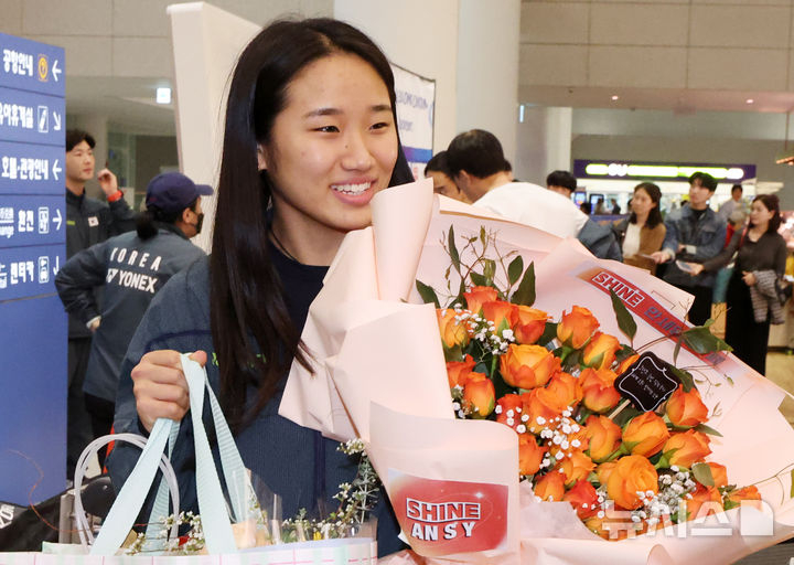 Ahn Se-young, who won the women's singles at the 2026 Asian Badminton Championships and achieved the Grand Slam, returns home through Incheon International Airport's Passenger Terminal 2 on the afternoon of the 13th and receives a bouquet of flowers from fans. /Photo = Newsis