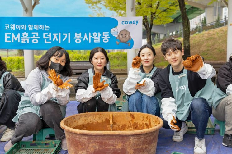 Coway executives and staff volunteers are making EM clay balls at Anyangcheon Multi-Purpose Plaza.