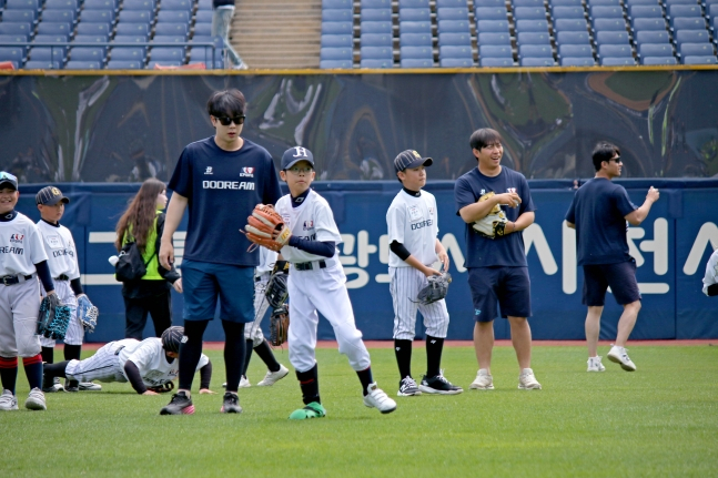 NC队的朴建宇（左）看着棒球希望之星们的训练，正在提出建议。 =图为，职业棒球选手协会提供。