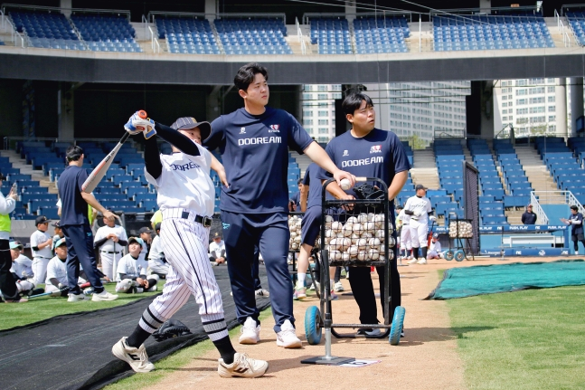 NC队的金亨俊(左二)正在"敲击"棒球诊所观看棒球希望之星的打击。 =图为，职业棒球选手协会提供。