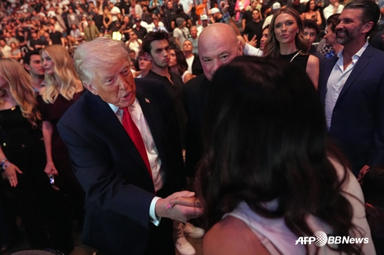 美国总统特朗普(左)在UFC体育场与球迷们打招呼。 =法新社BBNews=新闻1。