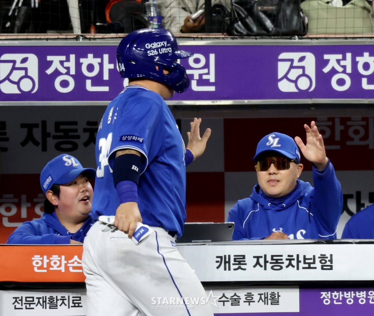 Samsung Lions' Choi Hyung-woo (center) is making a high five with head coach Park Jin-man after scoring with Kim Seo-hyun's wild pitch in the top of the eighth inning against the Hanwha Eagles in the 2026 KBO League at Hanwha Life Ball Park in Daejeon on the 14th. /Photo = Senior Reporter Kang Young-jo