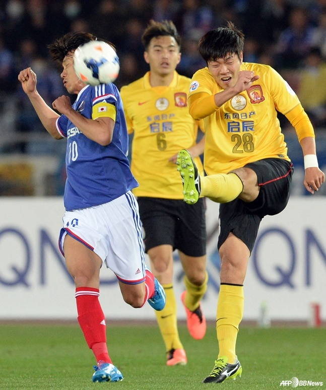 Shunsuke Nakamura (left) gets hit in the face by a powerful shot from Kim Young-gwon with his left foot. /AFPBBNews=NEWS1
