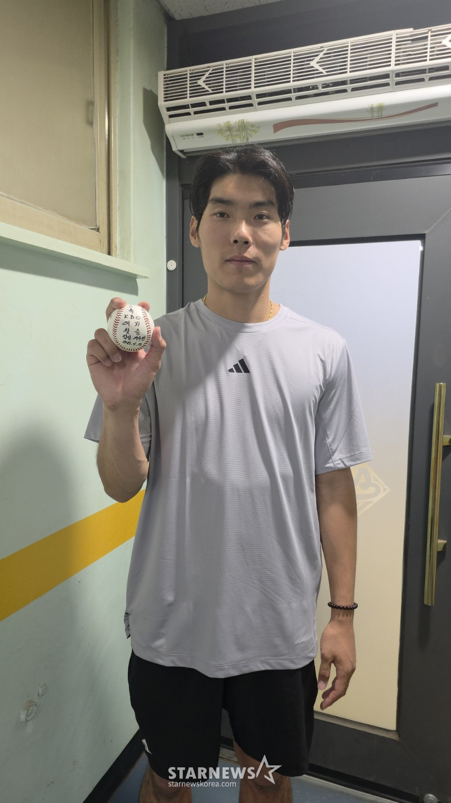 18日，斗山熊队的尹泰浩在蚕室与KIA队的比赛中取得出道首场胜利后，手里拿着首场胜利纪念球摆出造型，供记者们拍照。 =照片=金宇钟。