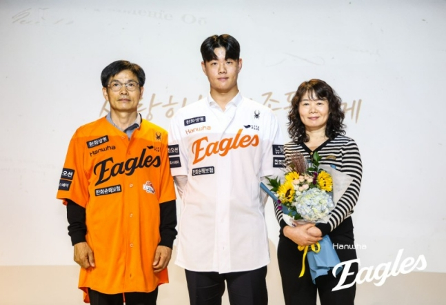 图为，去年10月，在新人选手入队仪式上，朴俊英（中）身穿韩华队队服与父母合影留念。 =韩华鹰队。