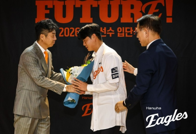 图为，去年10月，朴俊英（中）在新人选手入队仪式上从团长孙赫手中接过花束。 =韩华鹰队。