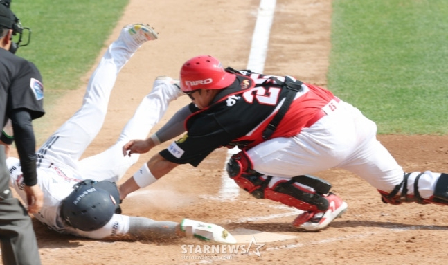 The 2026 Shinhan SOL KBO League game between Doosan Bears and KIA Tigers was held on the 19th at Seoul Jamsil Baseball Stadium. In the bottom of the 5th inning with one out and a runner on third base, Doosan's third baseman Park Chan-ho slid into home plate, twisting his body to tag the base during Park Jun-soon's ground ball to third, scoring the go-ahead run. KIA catcher Han Jun-soo is visible. /Photo=Kim Jin-kyung, Staff Reporter