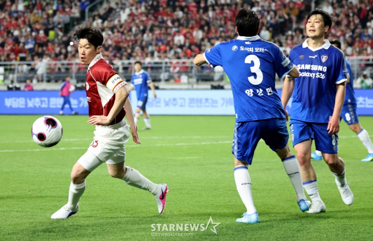 朴智星（パク·チソン、左）が水原三星（スウォン·サムスン）レジェンドとの試合でドリブルを試みている。 /写真=姜永祚（カン·ヨンジョ）先任記者