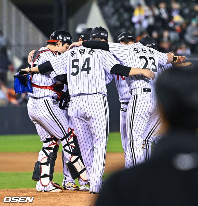 柳永灿（中）和奥斯汀（右）等LG队选手在胜利后一起在投手踏板上庆祝。 