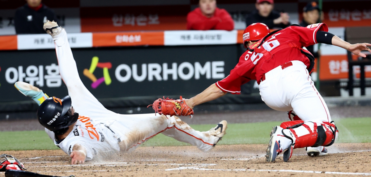 Hanwha Eagle Oh Jae-won (trái) ghi bàn trong trận đấu trên sân nhà với đội SSG Landers của giải Shinhan SOL KBO League 2026 được tổ chức tại Hanwha Life Ball Park ở Daejeon vào ngày 28 với một cú trượt tuyệt vời ở cuối hiệp 5. /Ảnh = News1 / Ảnh = (Daejeon = News1) Phóng viên Kim Ki Nam