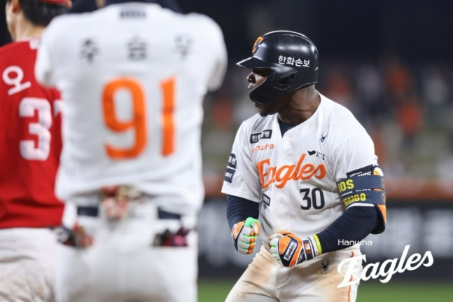 28日，在大田韩华生命球场举行的SSG Randers队与2026新韩SOL KBO联赛主场比赛中，韩华老鹰队（右）在延长赛第10回合末击出扳平比分的适时安打后，正在咆哮。 =韩华鹰队。