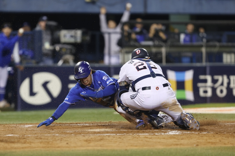 Samsung's Kim Sung-yoon scored during the top of the 10th extra inning of the Doosan game on the 28th, following Choi Hyung-woo's hit. On the right is Doosan catcher Yang Eui-ji. /Photo=Samsung Lions