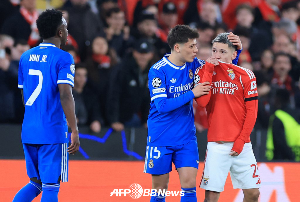 Джанлука Престиани (справа) разговаривает с Винисиусом Джуниором, прикрывая рот формой во время матча 1/16 финала Лиги чемпионов УЕФА с мадридским "Реалом" в феврале. /AFPBBNews =Новости 1