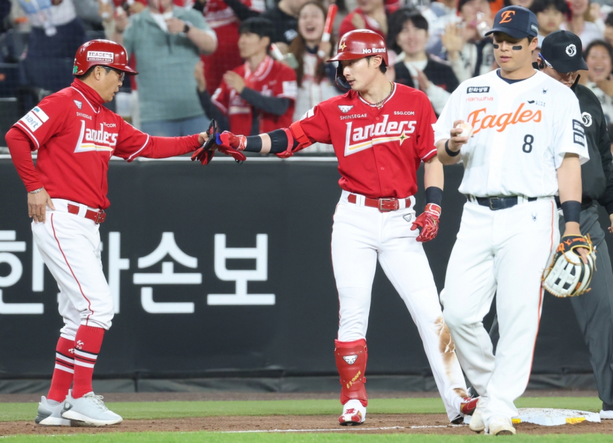 Choi Ji-hoon (giữa) của SSG Landers đang đập tay với huấn luyện viên Yoon Jae-guk sau khi đánh bại đối thủ ở gôn 3 vào đầu hiệp 8 trong trận đấu giữa Hanwha Eagle và Shinhan SOL KBO League được tổ chức tại Công viên Bóng sinh mệnh Hanwha ở Daejeon vào ngày 30. Ảnh = News1