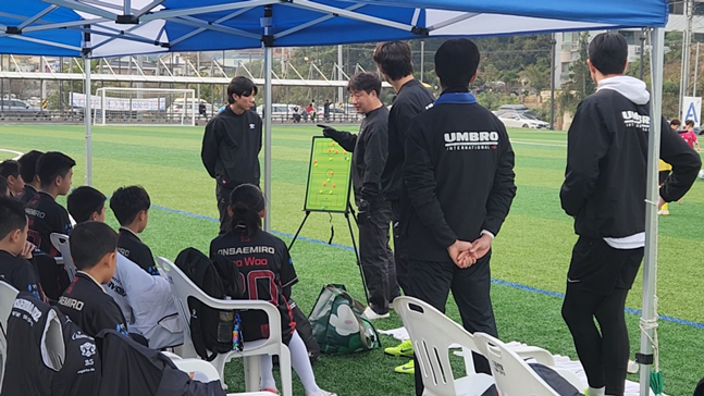 Huấn luyện viên Song Hyun Sik (giữa) đang giải thích chiến thuật cho các cầu thủ trẻ trong trận đấu. /Ảnh = Cung cấp FC Onsami